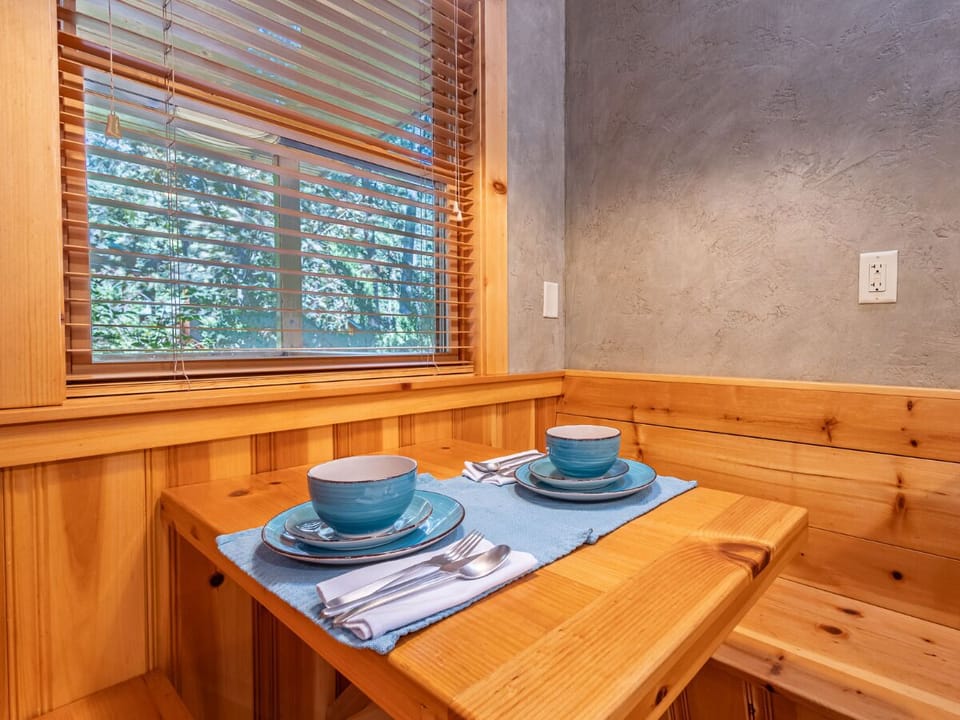 Enjoy a meal in this cozy dining nook, designed for intimate gatherings. The warm wood tones and natural light create a welcoming atmosphere, perfect for morning coffee or a quiet dinner for t
