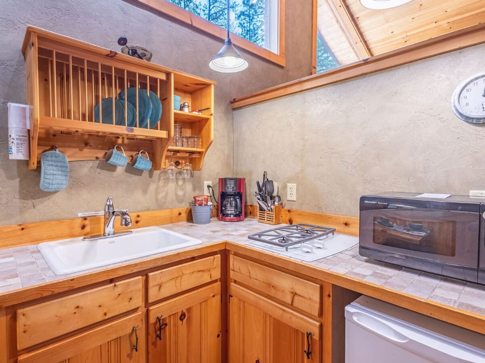 This cozy kitchen has everything you need, including a gas stove, microwave, and essentials. The natural light and warm atmosphere make it a delightful space to prepare meals and enjoy your st