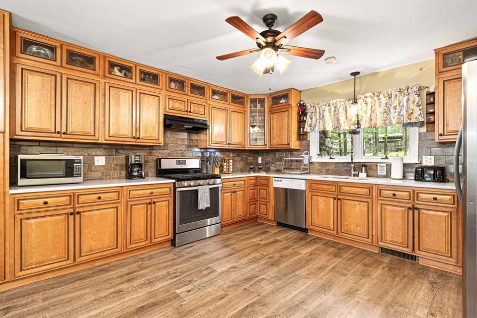 One of your 2 fully stocked kitchens - plenty of space! Hallway and front entrance seen at the back.