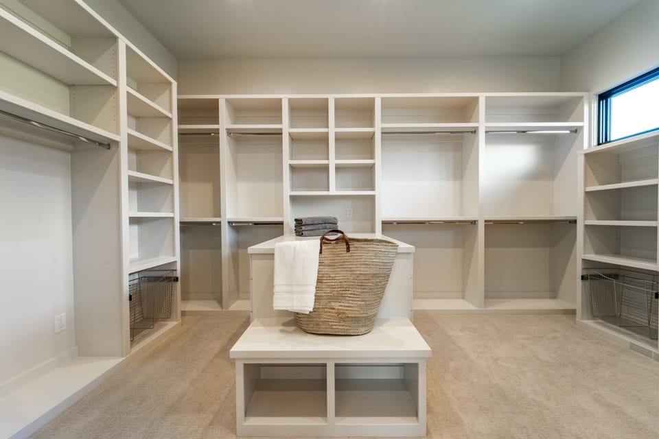 Spacious master bedroom closet which boasts a stackable washer and dryer.