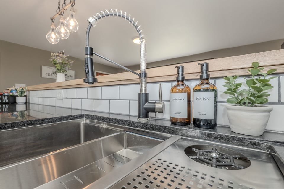 Updated sink area with dish soap, handsoap,cleaning supplies and dishwasher pods