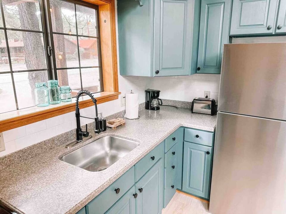 Modern convenience in the heart of the home: Well-equipped kitchen featuring coffee maker, refrigerator, and sink.