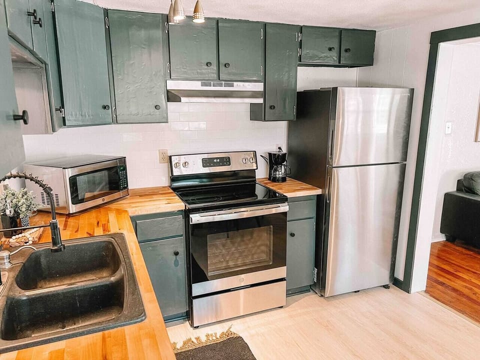 Efficient culinary haven! Discover the essentials in our kitchen view: refrigerator, oven, and sink.