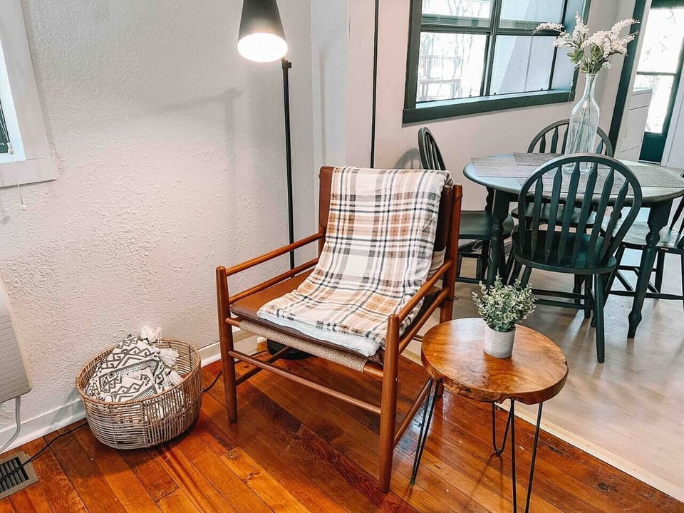 Seamless living and dining! Relax in our inviting space, where a cozy chair, small table, and lamp offer comfort and style.