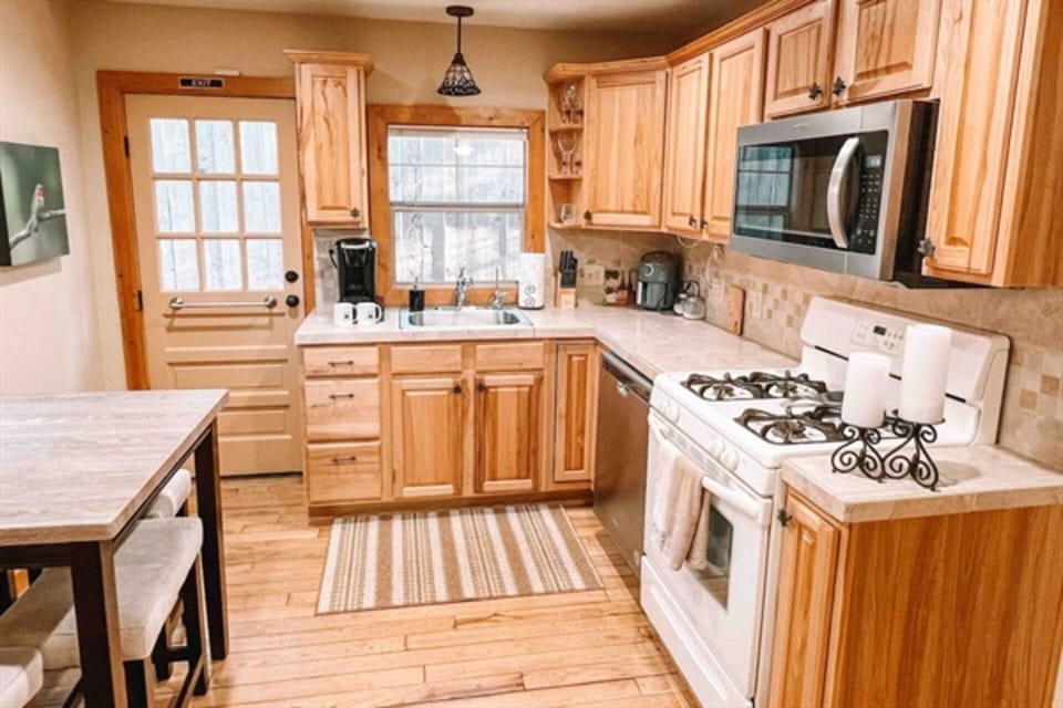 Fully stocked kitchen that includes pot, pans, spices, and coffee.