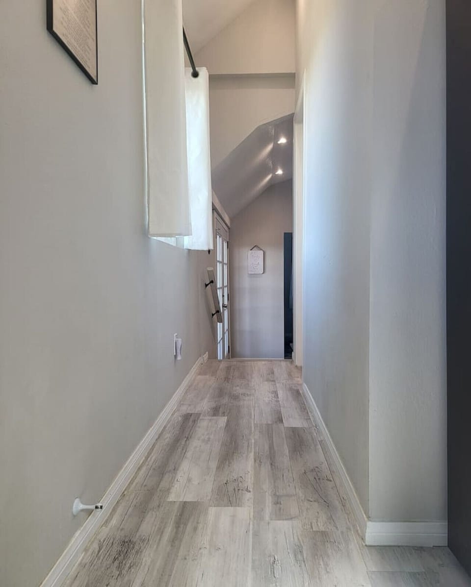 Hallway from the kitchen to the bathroom (on the right), and the living room and bedroom (down two steps).