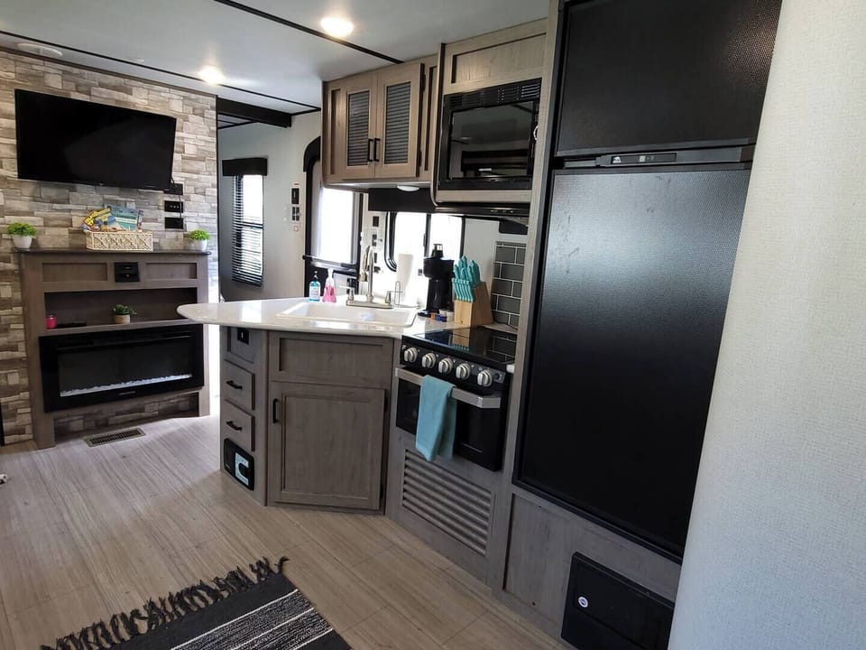 The open kitchen is stocked full with all of your essentials, a mini coffee bar, and even a fireplace for the perfect ambiance.