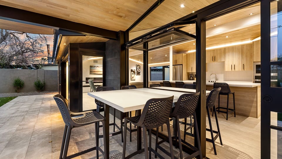 Stylish outdoor dining area with a covered patio and seamless indoor access.