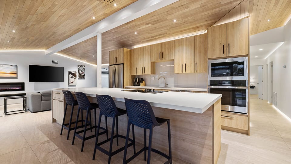 Open-concept kitchen with light wood cabinets, island seating, and flow.