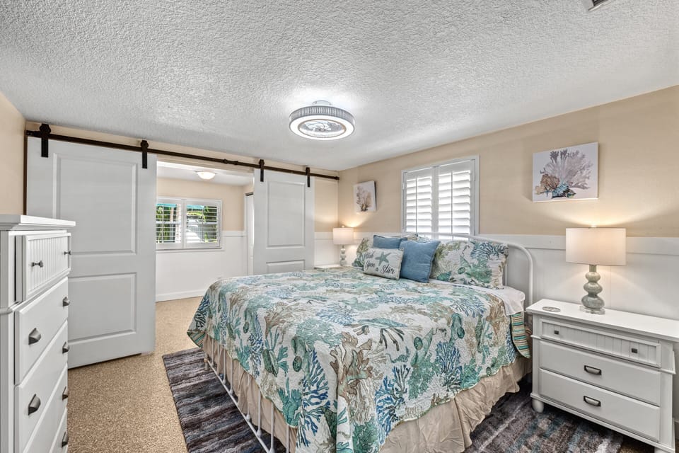 Wake up to soft sunlight streaming through coastal-inspired decor in a cheerful, restful retreat.