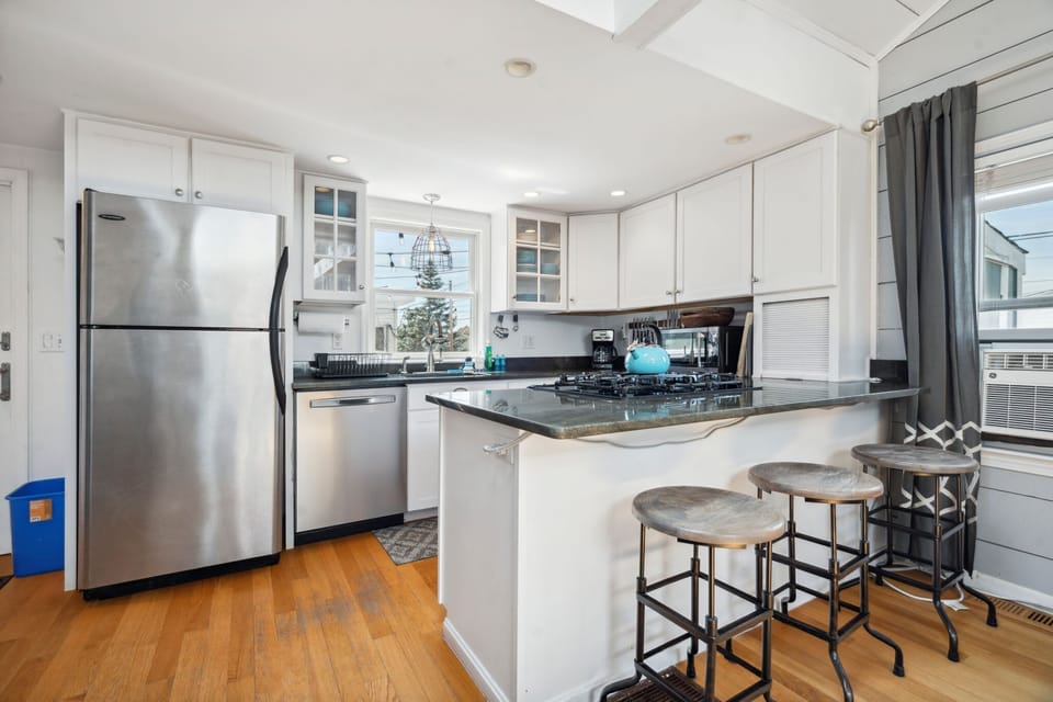 Fully equipped kitchen with all necessary appliances, 3-seater eat-in counter, and 6-person dining table