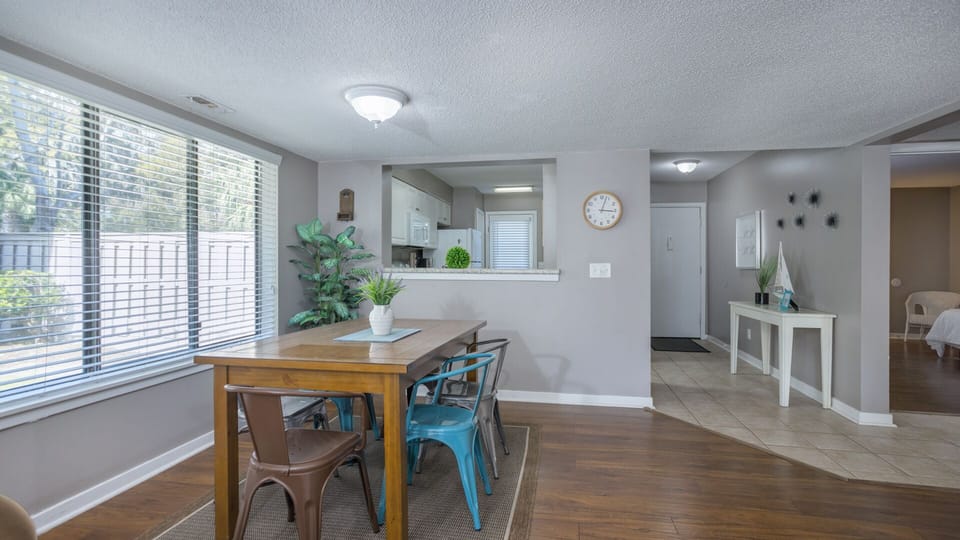 The living space flows seamlessly into the dining area and kitchen, featuring a breakfast bar with seating—ideal for casual meals or entertaining.