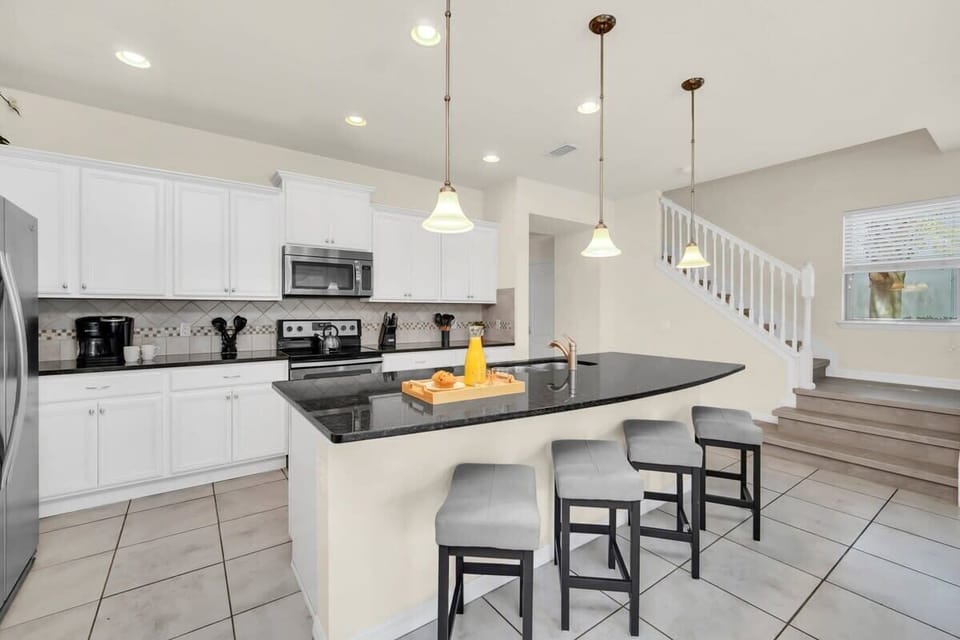 Modern kitchen with a black granite island and seating for four.