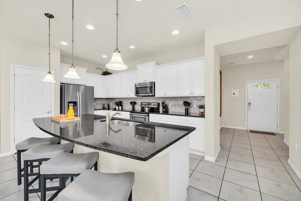 Modern kitchen with a large granite island and stainless steel appliances