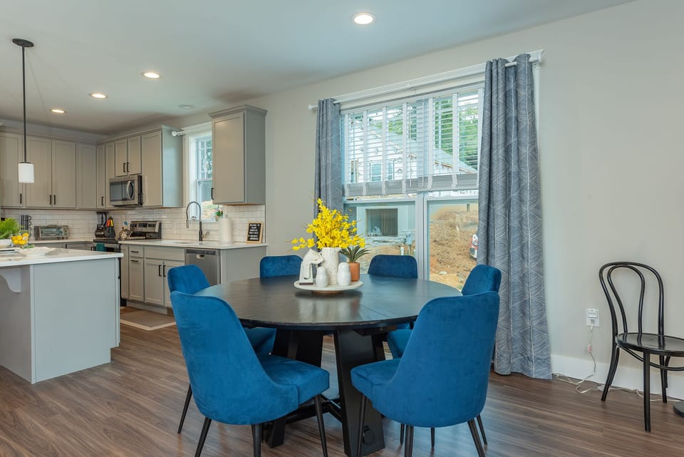 Open-concept, one level home with living room TV, sectional seating, dining for 6, and beautifully bright kitchen