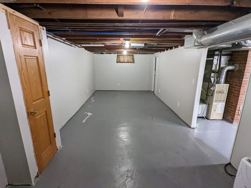 Unfurnished basement storage area. Dog crate is offered here for pets.