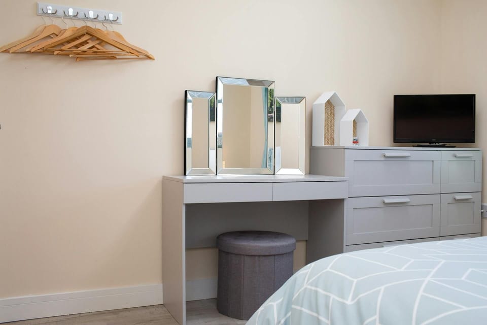Dressing table and chest of drawer with TV on top. Wall mounted hanging space