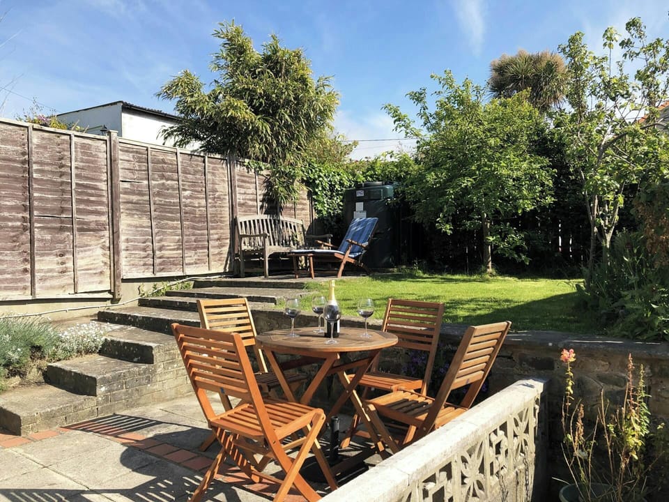Garden with small garden table and chairs, bench