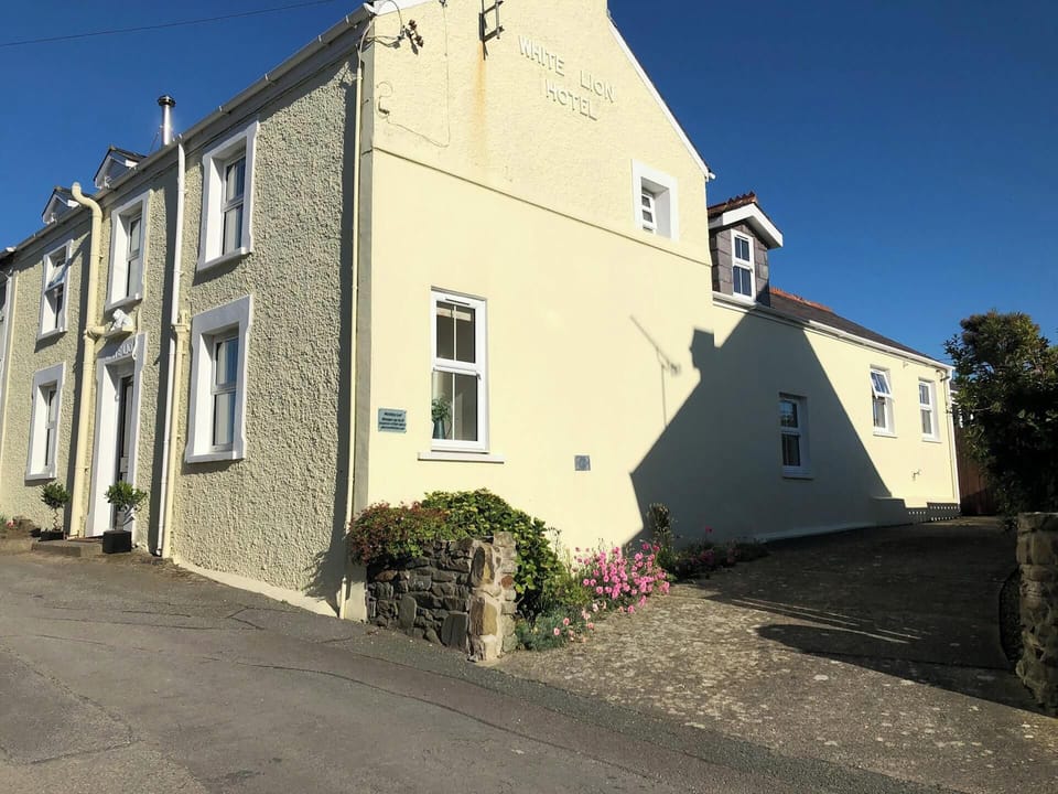 White Lion with driveway to the side and a small flower bed