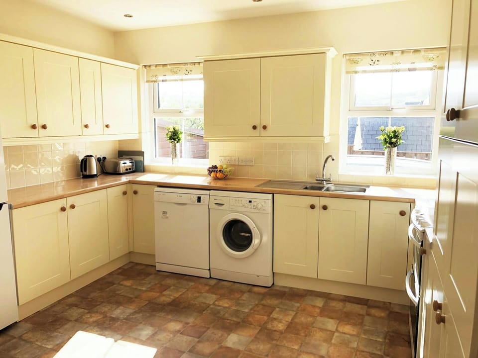 Kitchen with sink, cooker, washing machine, dishwasher, kettle and toaster