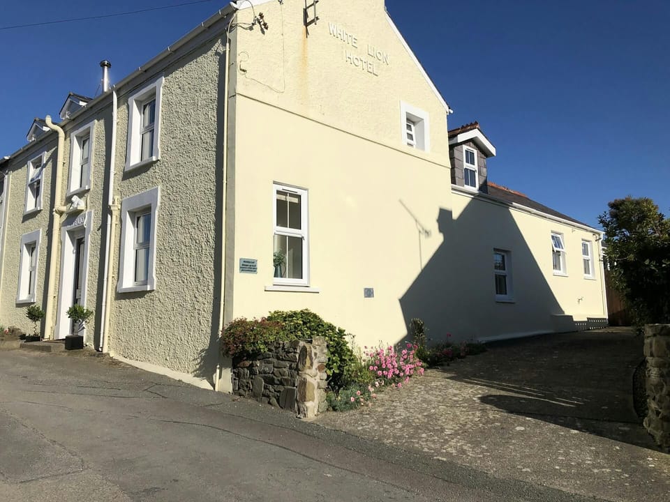 White Lion with driveway to the side and a small flower bed