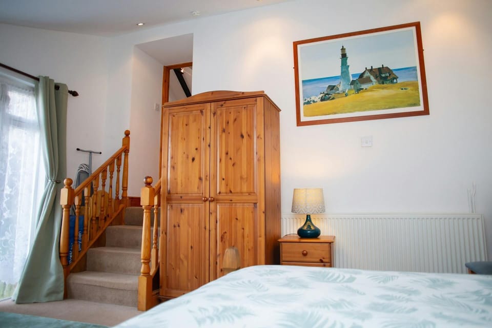 Kingsize bedroom with wardrobe and stairs leading to the living accommodation