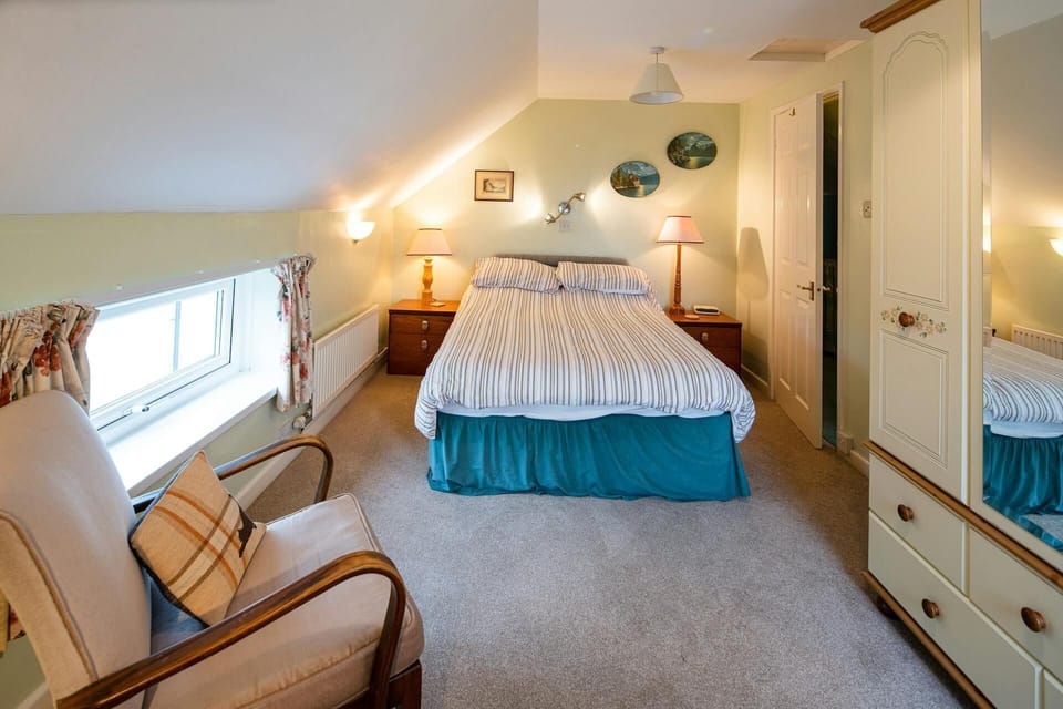 Double bed, bedside cabinets with lamps, large wardrobe with drawers and full length mirror. Occasional chair