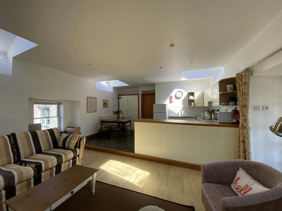 Living area with sofa, armchair, coffee table, dining table and 4 chairs