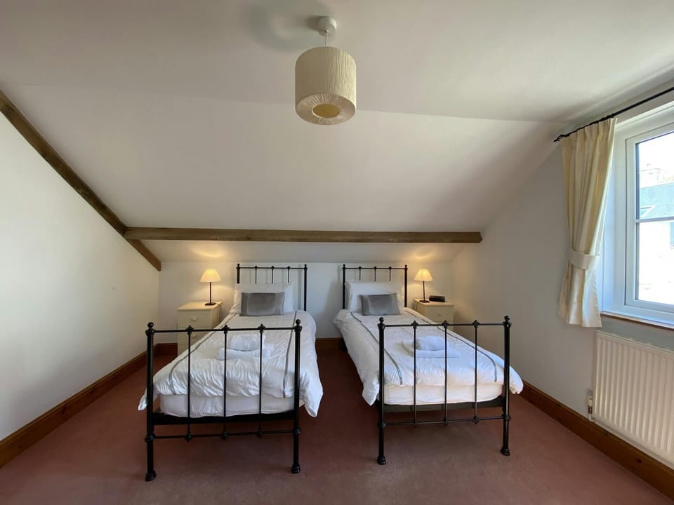 Metal framed twin single beds, bedside drawers with lamps, radiator and window