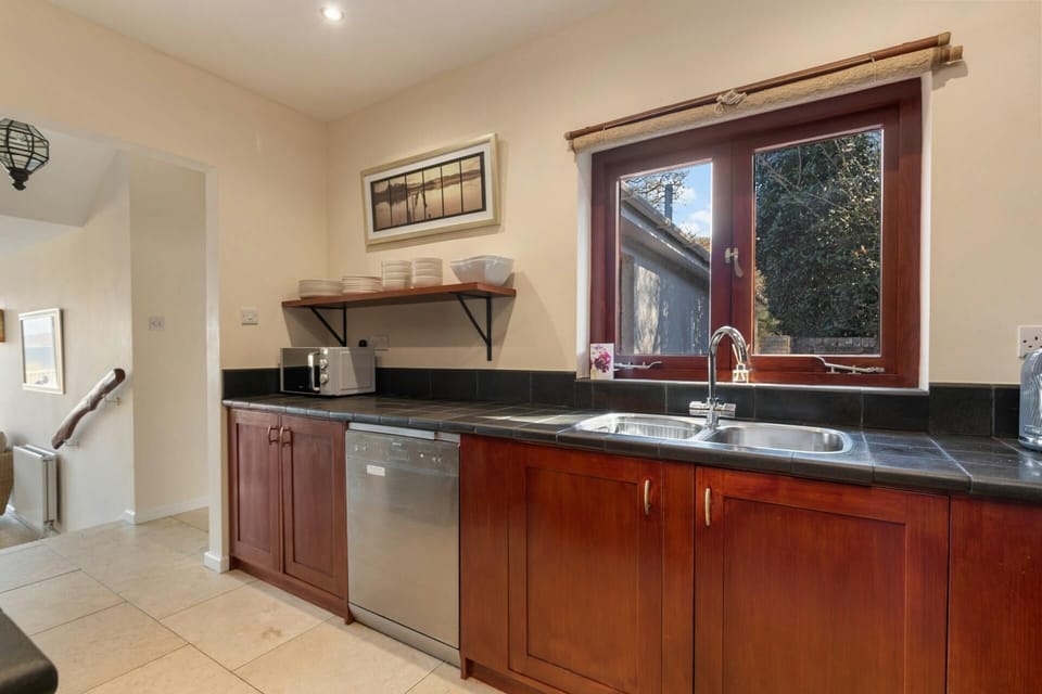 Kitchen with tiled floors and steps leading to the living accommodation