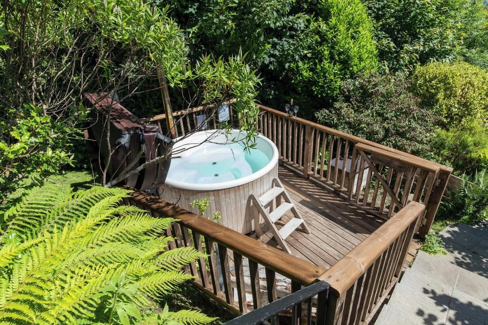 Steps leading from the terrace to a deck with hot tub on
