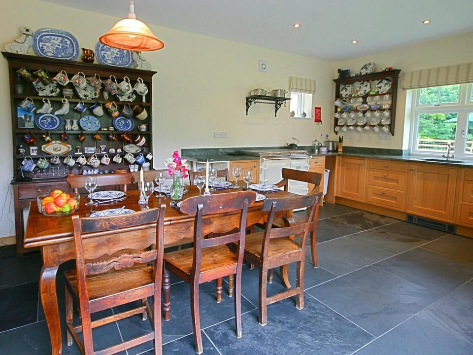 Kitchen with AGA, sink, toaster, dining table with seven chairs and dresser