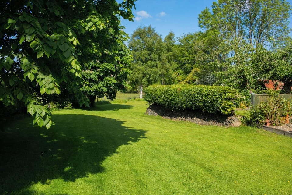 Large lawns and mature trees and flower beds