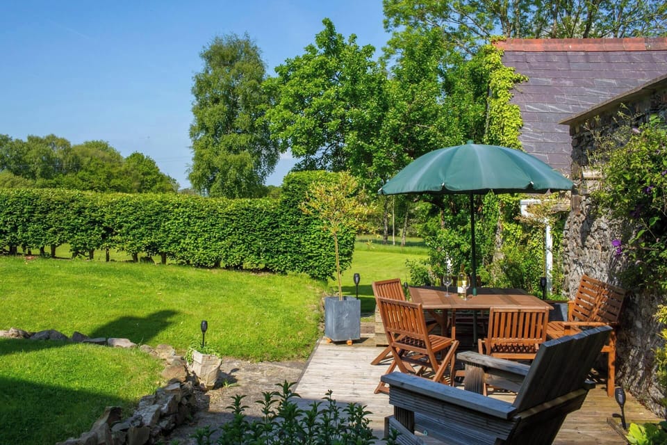 Patio area with table, parasol and chairs. Large lawns