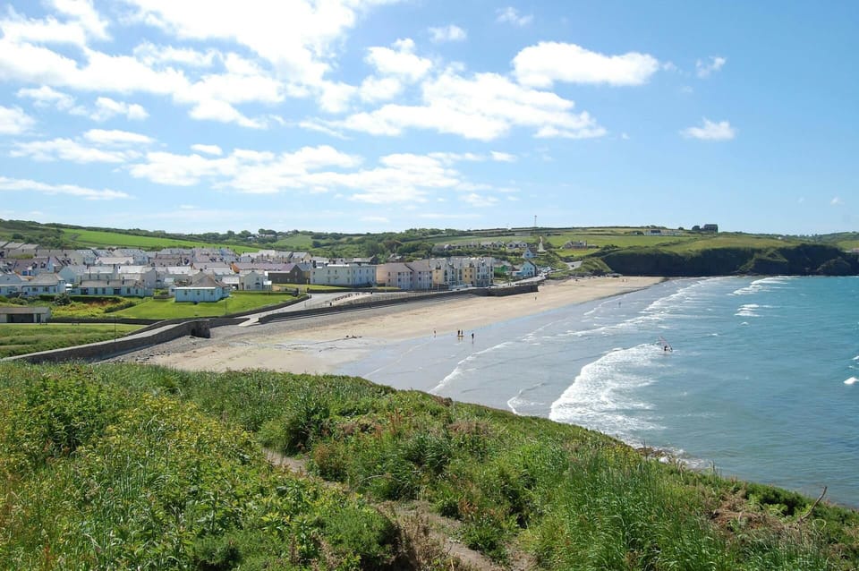 Coastal path and view of long beach and village at Broad Haven