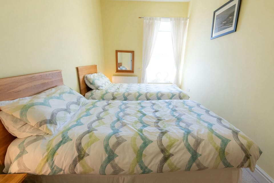 Twin bedroom with bedside table and lamps.