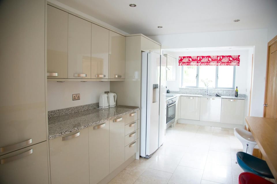 Kitchen with high and low level units, fridge freezer and breakfast bar