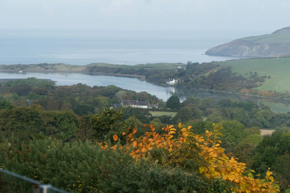 Looking over trees and countryside to coast with rocky headlands