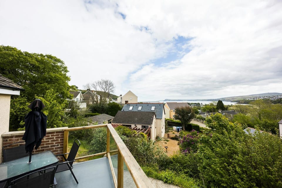 Outdoor table and chairs on the balcony with views looking over neighbouring properties.