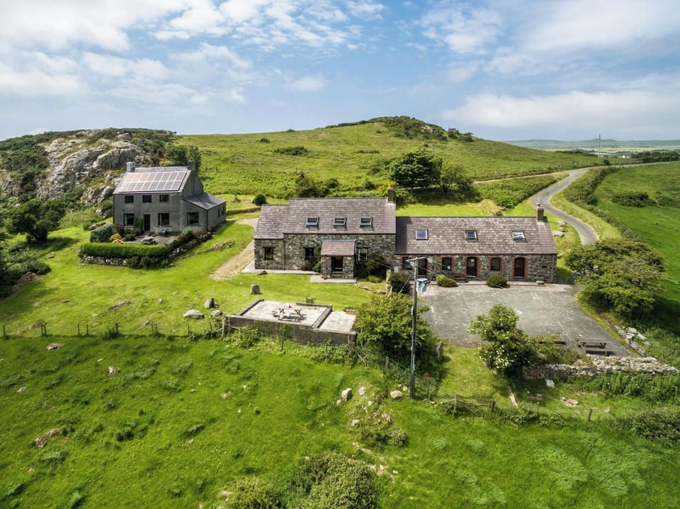 Aerial view of Y Bwthyn and surrounding countryside, sea in the distance