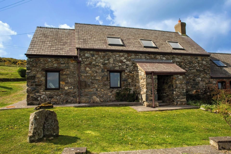 Y Bwthyn: outside of cottage showing porch and grassy area