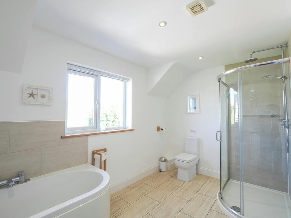 Bathroom with corner shower, bath, toilet