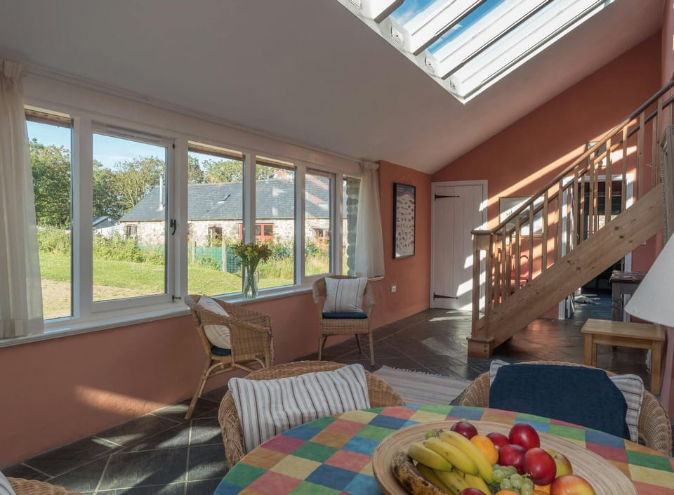 Entrance hall with ceiling windows, stairs to first floor, table and chairs