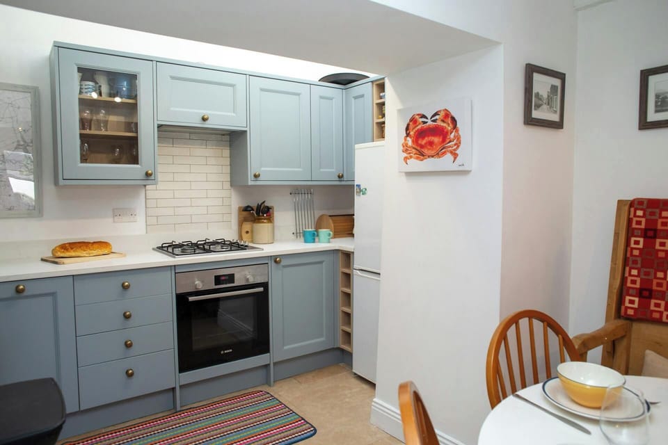 Kitchen with electric oven, gas hob and fridge/freezer