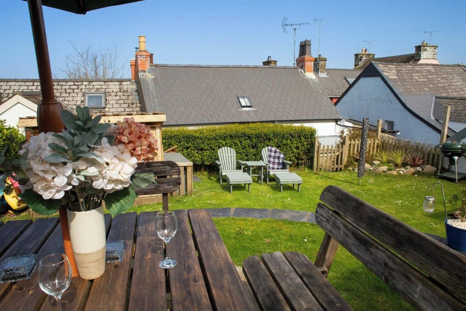 Garden with lawn area and gate leading down steps to the rear of the cottage