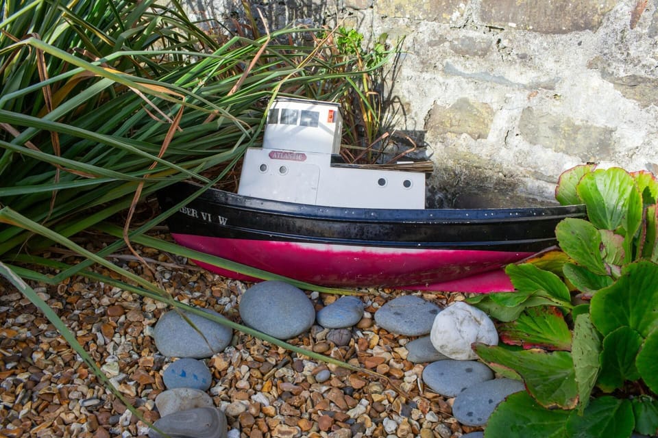 Boat ornament in a gravel raised bed