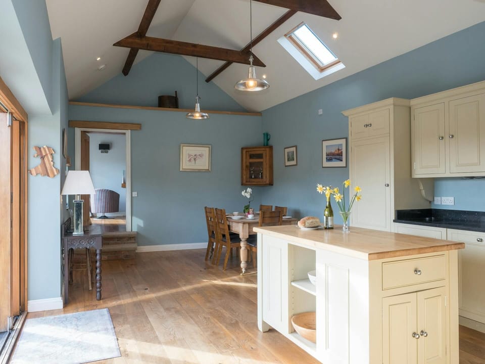 Kitchen in Lower Bubbleton with central island, units, dining table and chairs