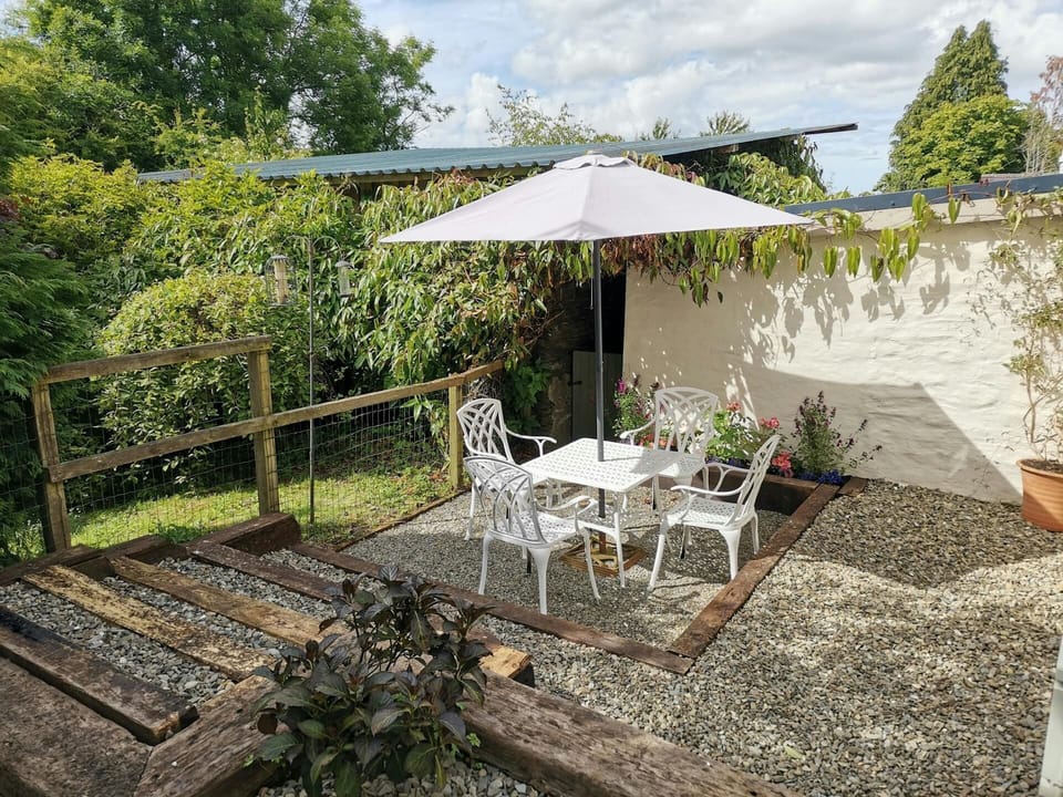 Outside table and four chairs with parasol in the garden