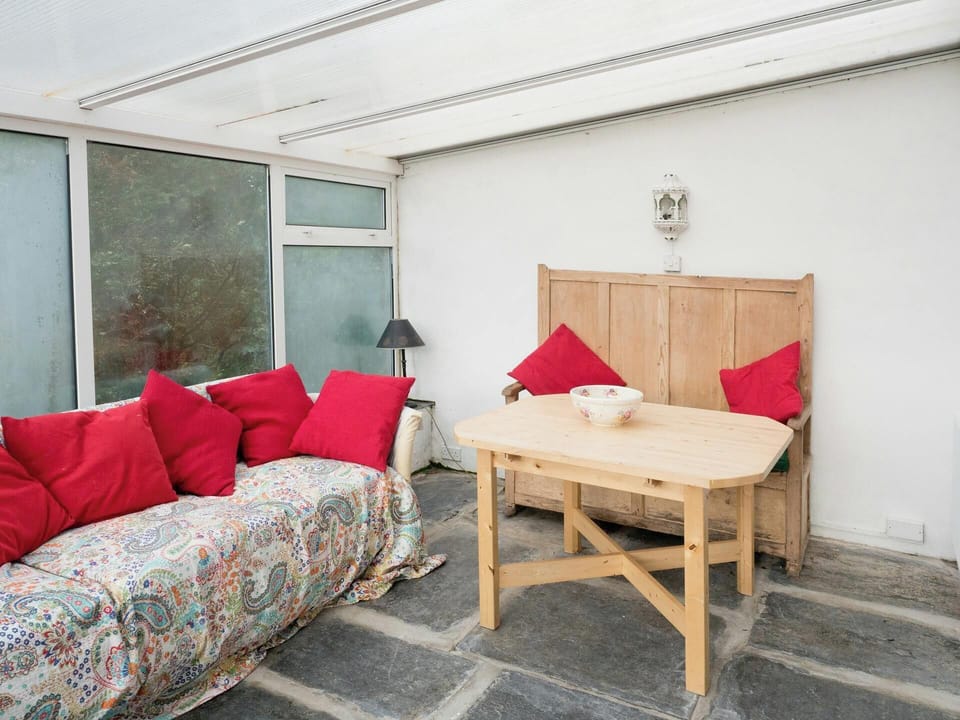 Slate floored conservatory in Ffynnonddewi with sofa, settle and table