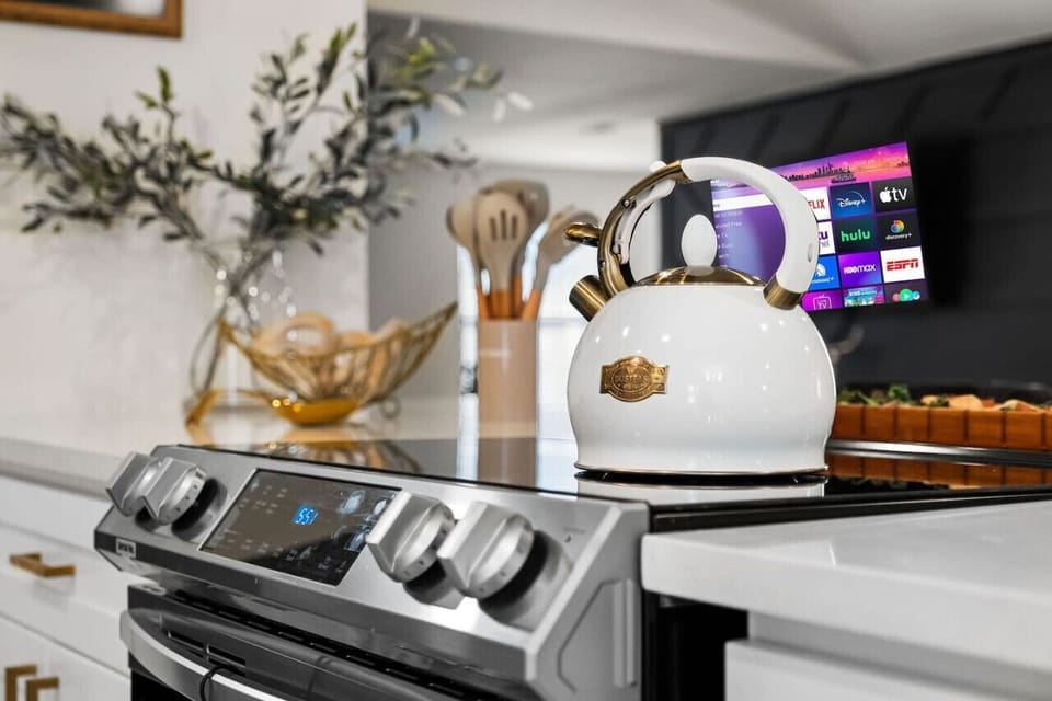 Luxury kitchen featuring a modern stainless steel stove, elegant white and gold tea kettle, stylish quartz countertops, and high-end amenities. Perfect for a comfortable and stylish stay, whether for a vacation, business trip, or extended getaway!